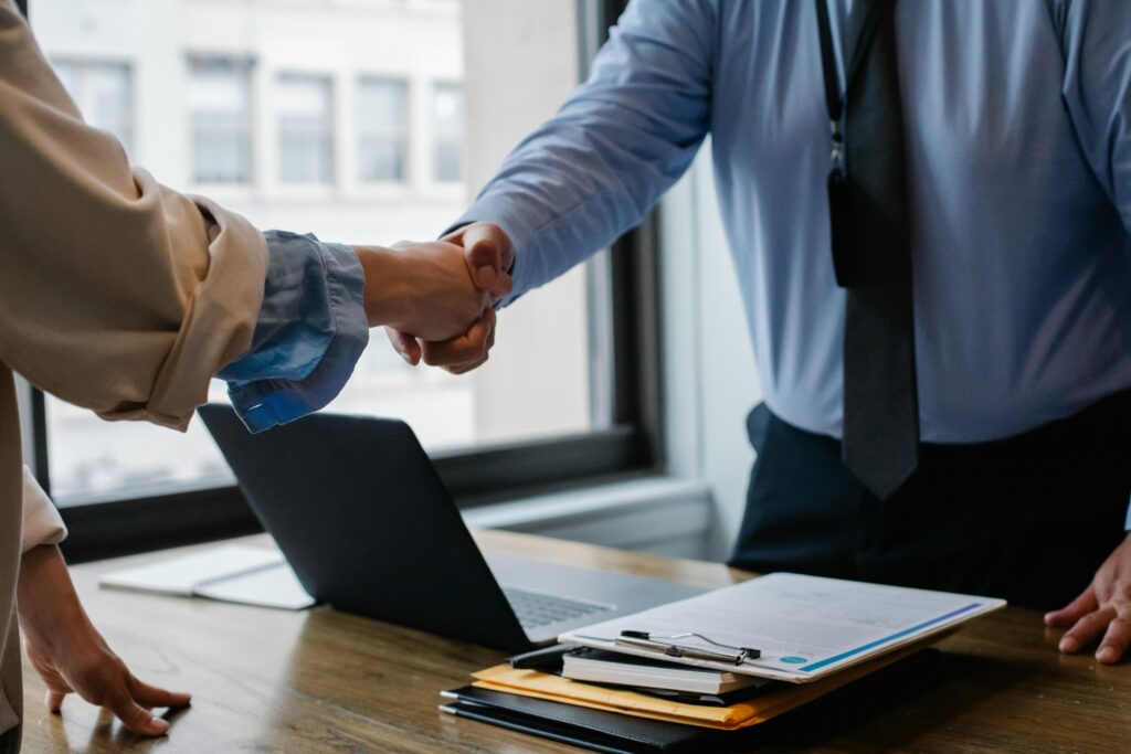 Insurance broker and client shaking hands in agreement