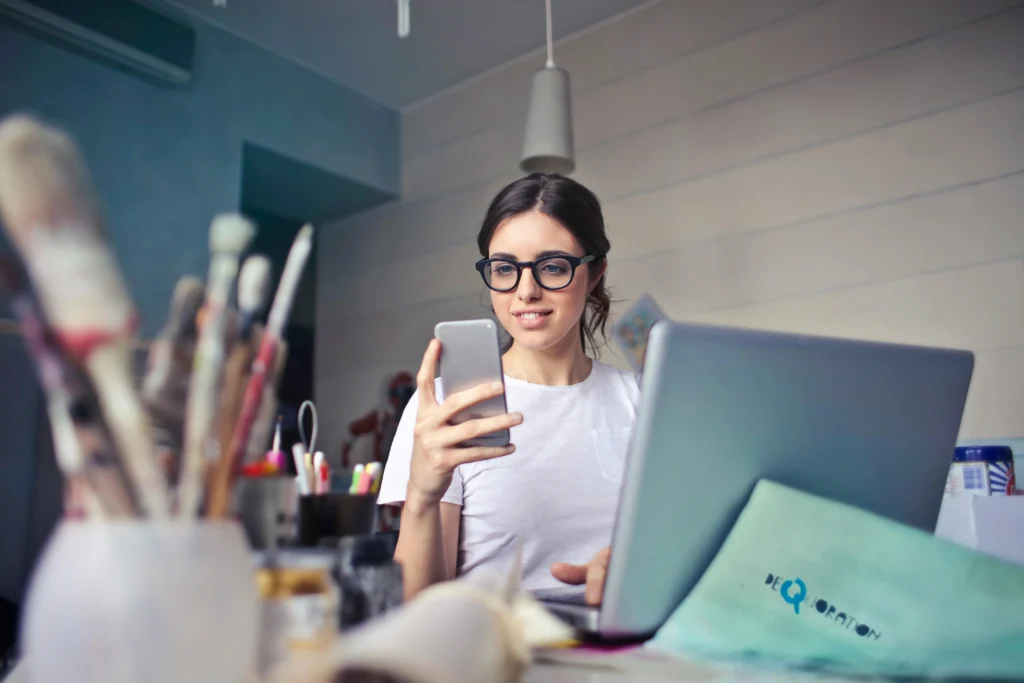 Small business owner in art studio looking at phone