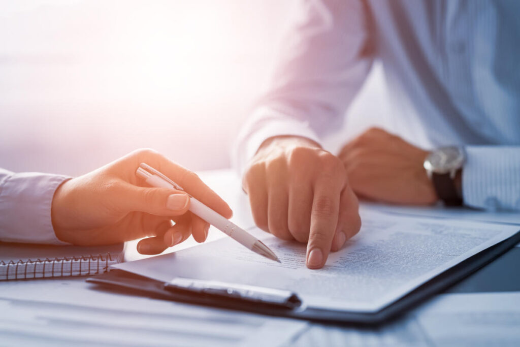 Insurance brokers pointing at insurance document