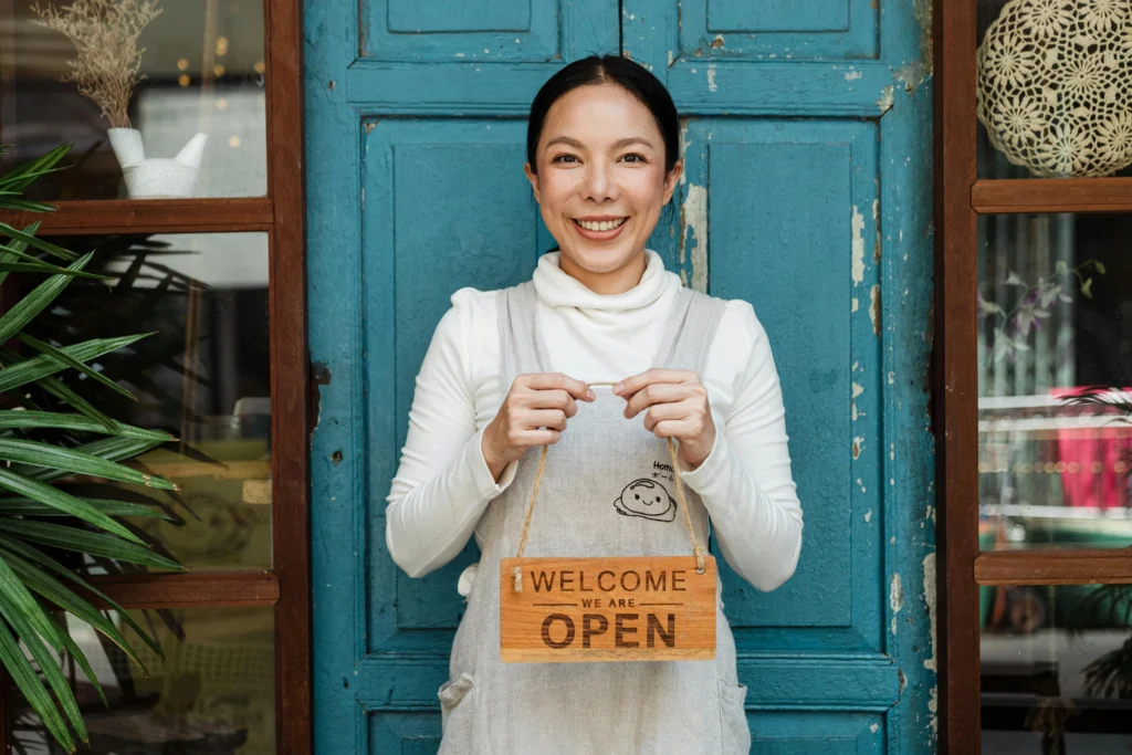 Female business owner holding open sign