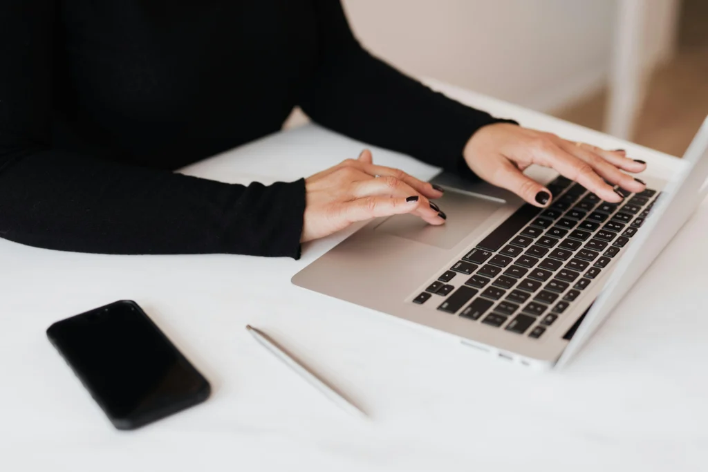 Close up of small business owners hands while working on laptop