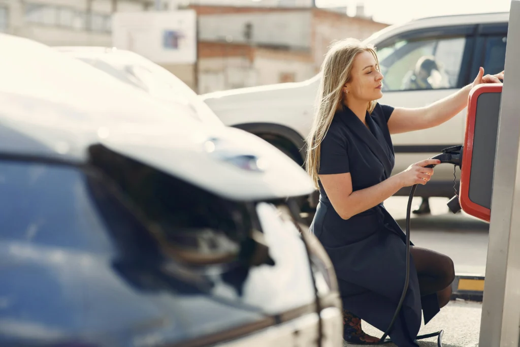 Small business owner charging electric car outside