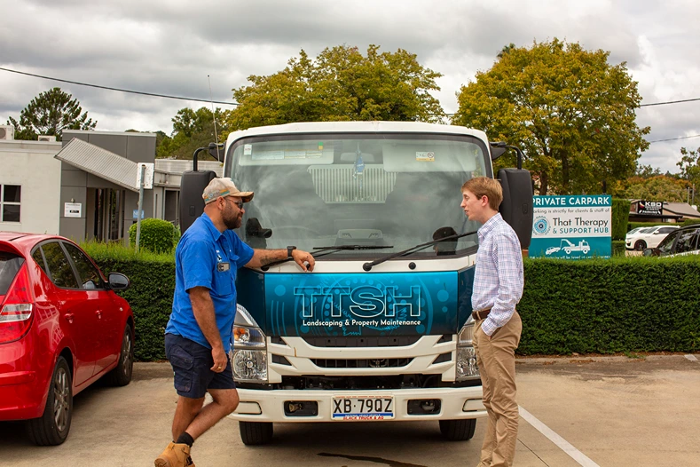 Home 4 Commercial vehicle insurance consultation with a landscaping business owner beside a work truck for All Stars Broker commercial vehicle cover.