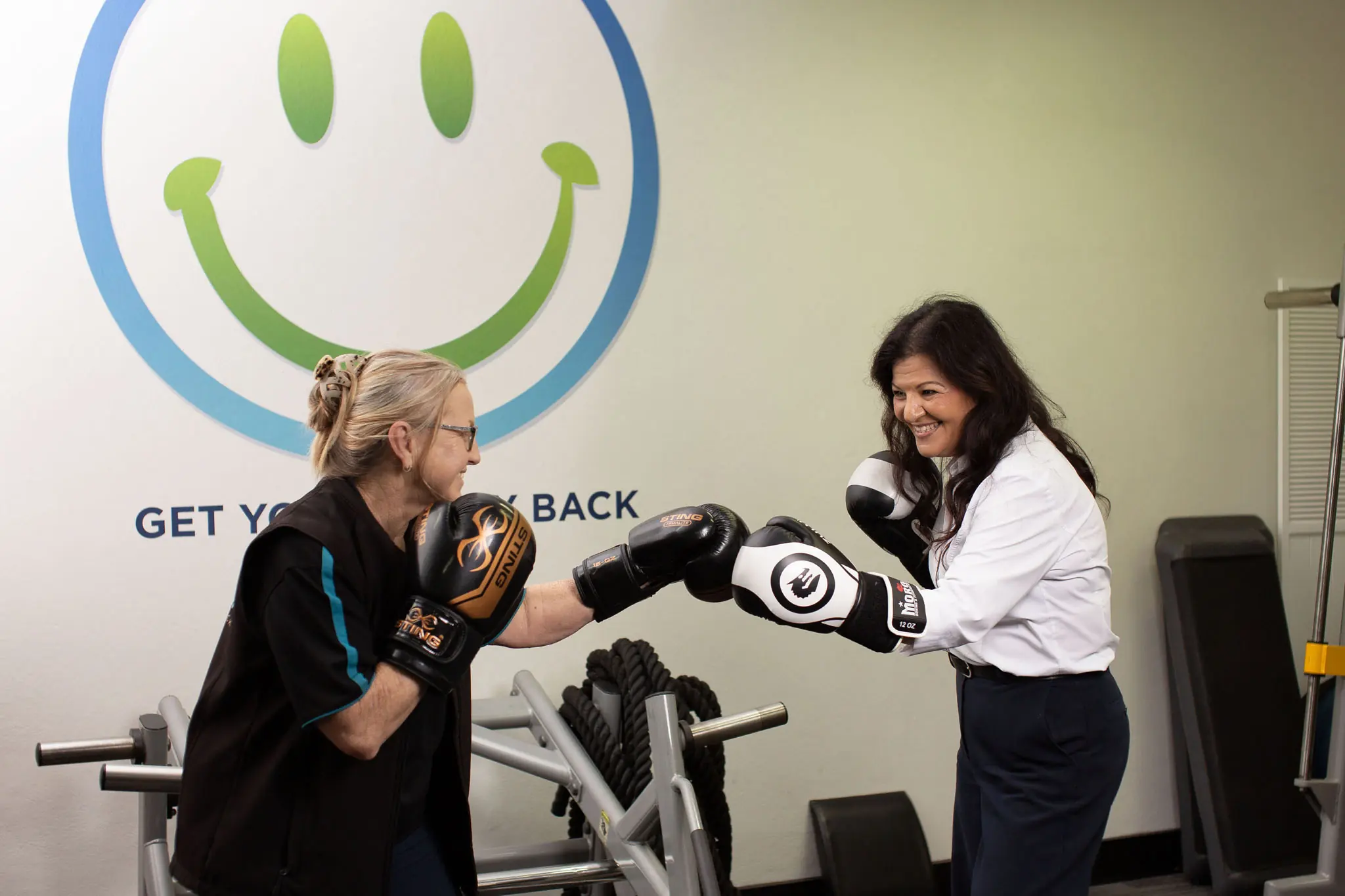 Home 13 Gym business insurance consultation with an All Stars Broker adviser and fitness trainer wearing boxing gloves.